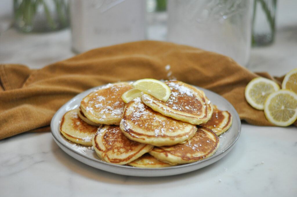 plate full of pancakes and lemons on top