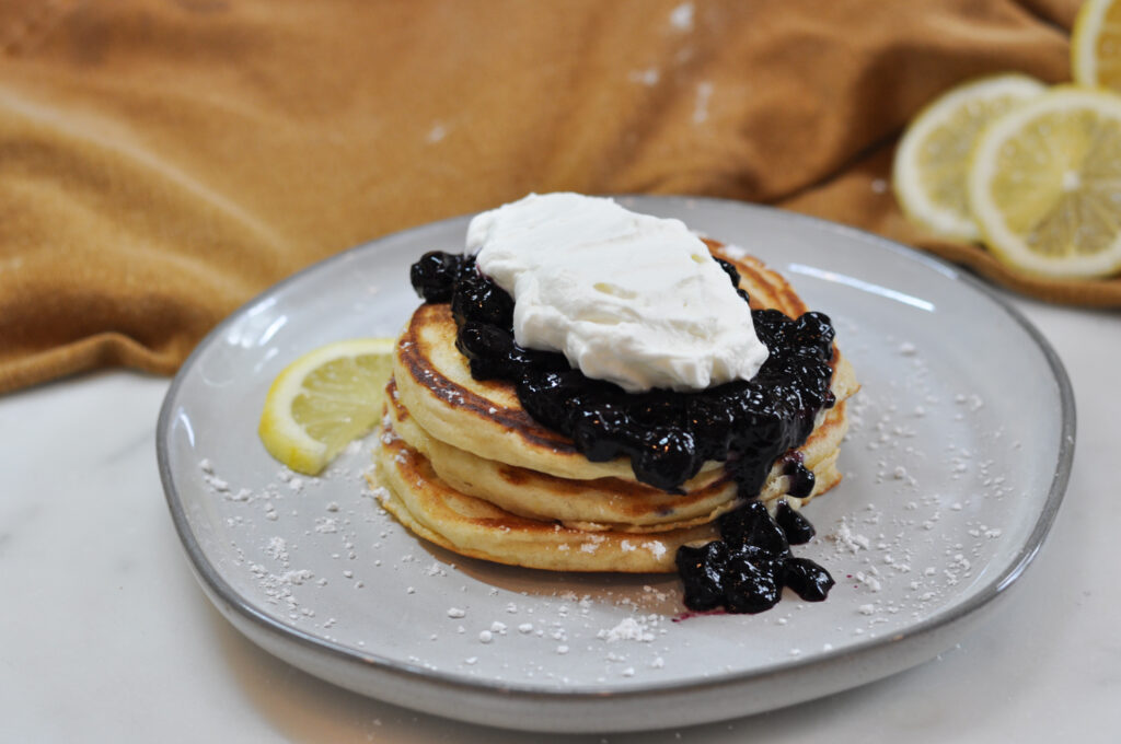 plate with stack of pancakes topped with blueberry jam.